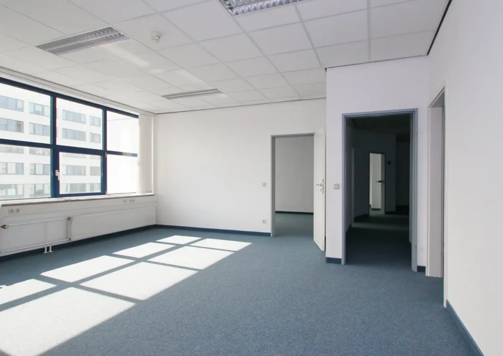 Leeres Büro mit Teppichboden und großen Fenstern
